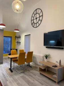 ein Esszimmer mit einem Tisch und einer Uhr an der Wand in der Unterkunft Mourneview Loft - Luxury Apartment in Newcastle