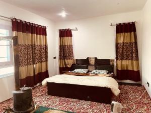 a bedroom with a bed in a room with curtains at Sunset View Gulmarg in Gulmarg