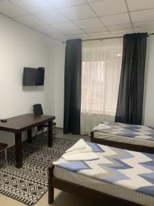 Zimmer mit 2 Betten, einem Schreibtisch und einem TV in der Unterkunft Hotel Resttime in Kowel
