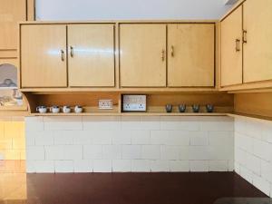 a kitchen with wooden cabinets and a counter with clocks at Simhagiri Sea Holiday Inn in Visakhapatnam