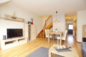 a living room with a television and a dining room at Ferienwohnung Papillon Boltenhagen in Boltenhagen