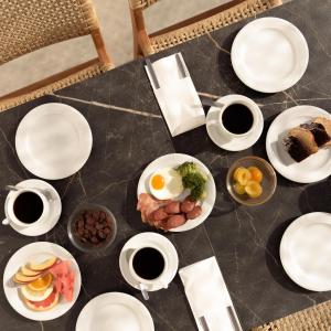 Sergios Hotel في خيرسونيسوس: طاولة مع أطباق من الطعام وأكواب من القهوة