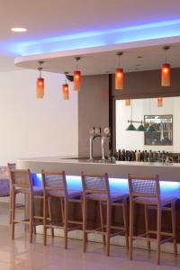 een keuken met een bar met stoelen en een bar bij Sergios Hotel in Chersonissos