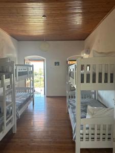 a room with four bunk beds and a hallway at Hostel on the Hill - by Filikuri Beach in Himare