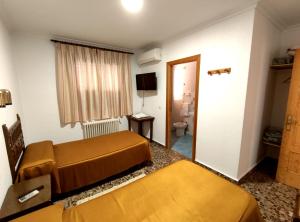 ein Hotelzimmer mit 2 Betten und einem Bad in der Unterkunft Hostal El Molino in Villahermosa