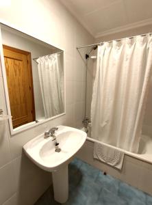 y baño con lavabo, espejo y bañera. en Hostal El Molino, en Villahermosa