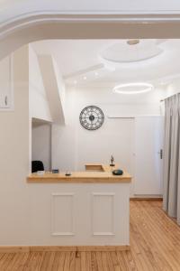 uma cozinha com um balcão e um relógio na parede em Aegli Suites em Levádeia