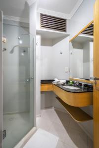 y baño con ducha y lavamanos. en Brivali Hotel e Eventos en Caçador