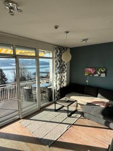a living room with a couch and a balcony at Appartement mit Seeblick & Seezugang in Sekull