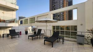 a patio with chairs and an umbrella on a building at DAMAC Park Central in Business Bay in Dubai