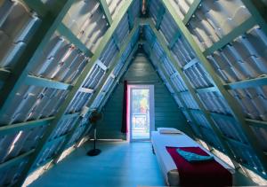 an attic room with a bed and a door at Falling Water Resort By Travent Mug in Sakleshpur +50 photos