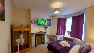 1 dormitorio con cama, TV y chimenea en Cosy Villa- 5 Bedroom Accommodation Great For Longer Stays!!! en Chatham