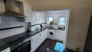 a kitchen with a sink and a washing machine at Cosy Villa- 5 Bedroom Accommodation Great For Longer Stays!!! in Chatham