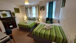 a small room with two beds and a fireplace at Cosy Villa- 5 Bedroom Accommodation Great For Longer Stays!!! in Chatham