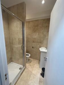 ein Bad mit einer Dusche und einem WC in der Unterkunft Stylish and cozy flats in London