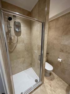 uma casa de banho com um chuveiro e um WC. em Stylish and cozy flats em Londres