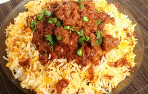 talerz żywności z mięsem i ryżem w obiekcie Dubai Hotel & Restaurant Kumarakom w mieście Kumarakom
