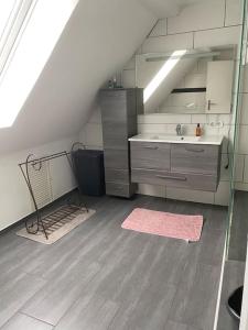 W łazience znajduje się umywalka i lustro. w obiekcie Loft Wohnung mit toller Aussicht w mieście Meßstetten