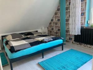 a bedroom with a bed with blue rugs in it at Loft Wohnung mit toller Aussicht in Meßstetten