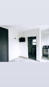 a white kitchen with a sink and a toilet at Zindiza Guesthouse 2 in Del Judor