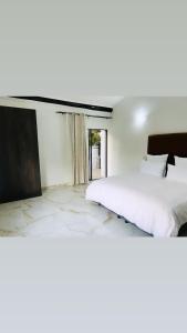 Del Judor的住宿－Zindiza Guesthouse 2，一间卧室设有一张大床和一个窗户。