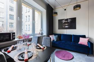 un soggiorno con tavolo e divano blu di Luxury Apartments in the City Center a Varsavia