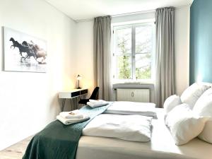 1 dormitorio con 1 cama con 2 almohadas blancas en E&K living - city central - design apartment - kitchen - free parking, en Gersthofen