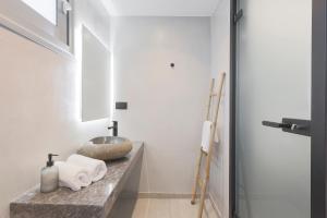 a bathroom with white walls and a counter with a sink at San Panteleimon in Paralia Panteleimonos