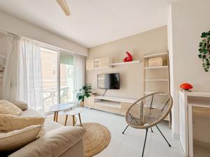 a living room with a couch and a tv at 400m playa con WiFi AC y piscina in Puerto de Gandía