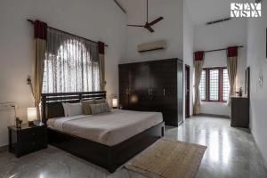 a bedroom with a large bed and a large window at StayVista at Periyar Palace- Pet Friendly, River View Villa with Garden in Cochin