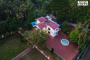 una vista aérea de una casa con piscina en StayVista at Periyar Palace- Pet Friendly, River View Villa with Garden, en Kochi