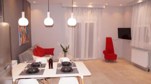 uma sala de estar com uma mesa branca e cadeiras vermelhas em Corfu Luxury Apartment, Tranquility, Mountain & Sea Views em Agios Gordios