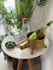 Butik Art Hotel في بودابست: طاولة مع زجاجة من الشمبانيا ووعاء من ellery