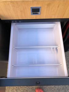 an empty refrigerator with its door open on a table at Dacia Dokker Camperiz in Palma de Mallorca