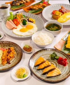 a table filled with plates of food and bowls of food at Hotel JAL City Bangkok in Bangkok