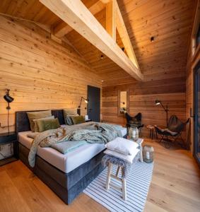 a bedroom with a large bed in a wooden room at Roubenka Smetanka in Smetanova Lhota
