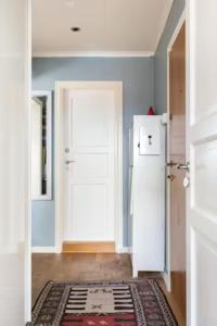 a kitchen with a white refrigerator and a door at Cosy room in a family flat in Oslo