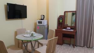 a small room with a table and a microwave at HOTEL BNL in Kalibo