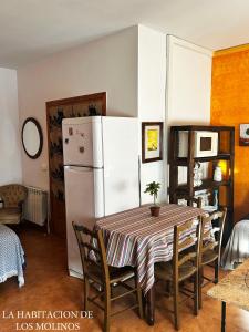 a kitchen with a table and a white refrigerator at Habitacion de los molinos in Mota del Cuervo