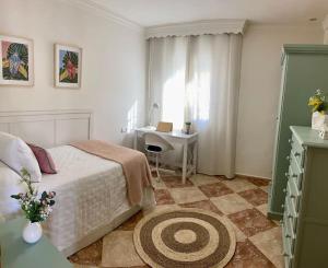 een slaapkamer met een bed en een bureau. bij Casa encantadora y confortable en Málaga. in Málaga