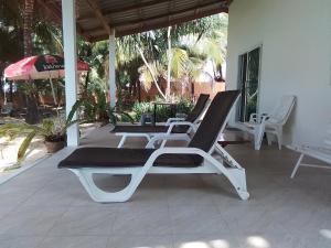two lounge chairs and an umbrella on a patio at The Rock Coco Villa in Ban Laem Pom