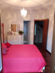 ein Schlafzimmer mit einem großen Bett mit einer rosa Decke in der Unterkunft VILLA CARMEN in Montesilvano Marina