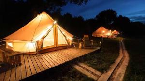 Wong Deso Camping في سمينياك: خيمة كبيرة مع سطح خشبي في الليل
