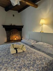 een slaapkamer met een groot bed en een open haard bij Il Vicolo agli Orti - Centro storico - Lake Como in Bellano