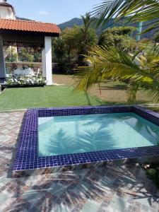 a swimming pool with blue tiles on the ground at FERRINGHI HOUSE with POOL, BBQ SET, 5 MINUTES WALK to BEACH in Batu Ferringhi