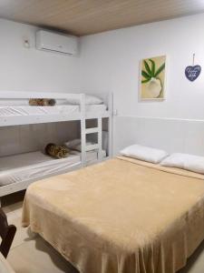 2 beliches brancos num quarto branco em suites com cozinha compacta em Cabo Frio