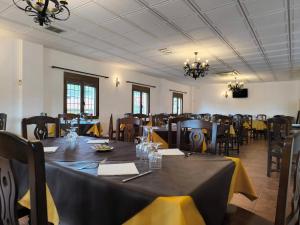 a dining room with tables and chairs with yellow napkins at Masia Del Cura in Rubielos de Mora