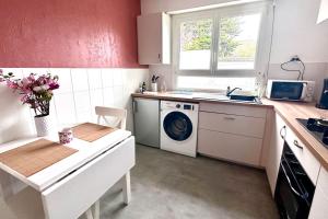 a kitchen with a washing machine and a sink at Le Noyer by Póm in Lorient