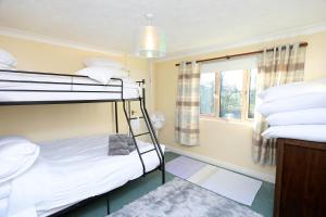 um quarto com 2 beliches e uma janela em Picturesque Family Hideaway Chipping Ongar Essex em Fyfield