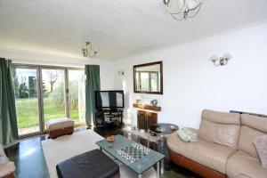 uma sala de estar com um sofá e uma televisão em Picturesque Family Hideaway Chipping Ongar Essex em Fyfield